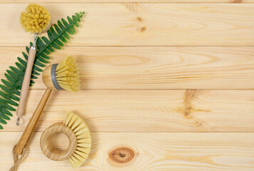 Natural cleaning bamboo, coconut dish brushes on wooden table. Eco friendly with No plastic kitchen and home cleaning. Top view, flat lay. Sustainable lifestyle, Zero waste concept.