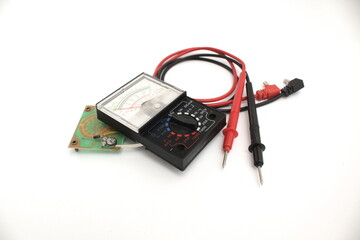 Broken analog multimeter and circuit board isolated on white background. 