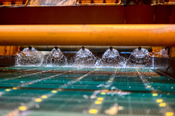 Vibrating screen, ore washing with liquid. The liquid is poured out in a fan-like stream from...