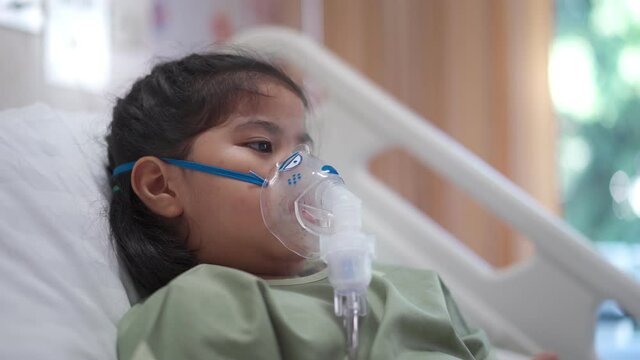Asian girl 7 year old in hospital using inhaler containing medicine, RSV, Respiratory Syncytial Virus
