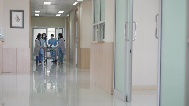 Emergency Department Doctors and group of Push Stretcher with injured Patient towards the emergency or Operating Room at hospital
