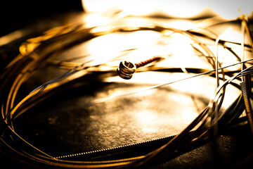 Closeup of Ball End on Guitar String Surrounded by Circle of Used Loose Guitar Strings