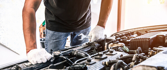 Car care maintenance and servicing, Close-up hand technician auto mechanic using the wrench to...