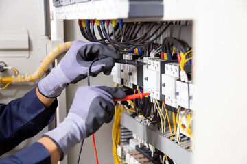Electrician engineer tests electrical installations and wires on relay protection system....