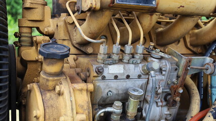 Old diesel pump on engine. Heavy equipment silver nozzle pump dirty yellow. Selected focus