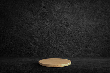 Round wooden product stand on black wall texture rough background dark stone wall or grunge background with black.