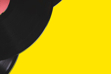 old vinyl records on a yellow background close-up