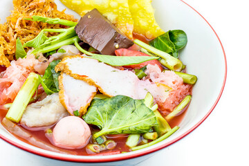 Thai style instant noodles soup in bowl, Yentafo with Thai herbs, Thai food, Noodle soup on white background.