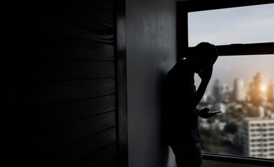 silhouette of a person standing behind a window