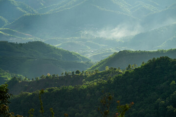 green mountains with thin smoke