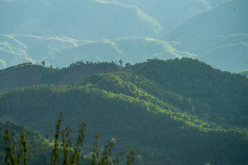 green mountains with thin smoke