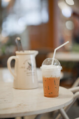 Iced coffee. A takeaway plastic cup of iced cappuccino. Soft focus on the plastic dome of the coffee.