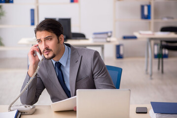 Young male employee working in the office