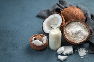 Coconut milk, flour and coconuts on a blue background.