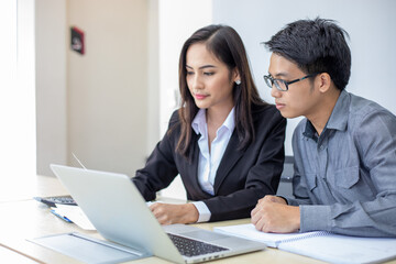 Asian businessmen and group using notebook for business partners discussing documents and ideas at meeting and business women smiling happy for working