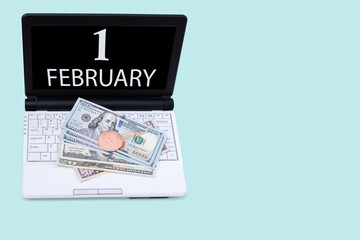 Laptop with the date of 1 february and cryptocurrency Bitcoin, dollars on a blue background. Buy or sell cryptocurrency. Stock market concept. - obrazy, fototapety, plakaty