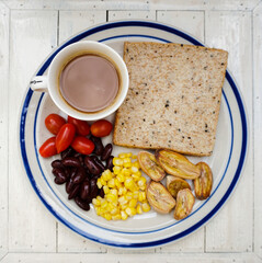 Healthy breakfast for dieting, Top down view of Breakfast dish on a white wooden background, Bread with hot coffee, boiled corn, baked banana, red beans and cherry tomatoes