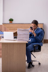 Young male employee unhappy with excessive work in the office