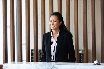 Friendly receptionist woman working at desk in hotel lobby. Leisure and travel at holidays.