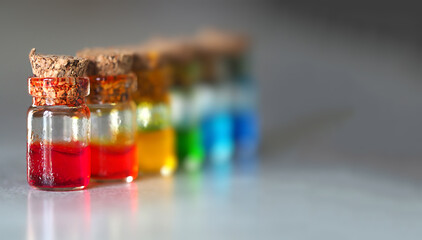 small glass jars with multi-colored liquids horizontal image with soft focus, copyspace