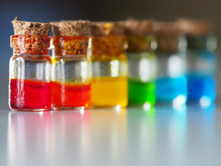 small glass jars with multi-colored liquids horizontal image with soft focus, copyspace