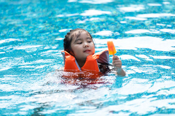 Happy Asian family vacation. Young Asian father with son and daughter enjoy by swimming pool at the hotel. Happy family summer vacation concept.