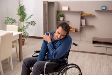 Young man in wheel-chair suffering at home