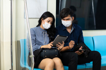 Crowd of passengers on Urban Public Transport Metro. Asian people go to work by public transport. Face Mask protection against virus. Covid-19, coronavirus pandemic
