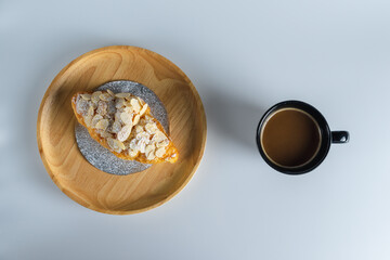 Delicious croissants and coffee cup on wooden plate. Freshly baked.