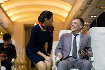 Asian beautiful flight attendant working in airplane cabin. Service mind. air hostess. Stewardess...