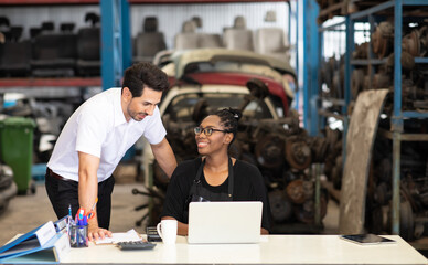 Fototapeta na wymiar African American female worker and man customer choose and inspecting car part products while working in a old car part warehouse store.