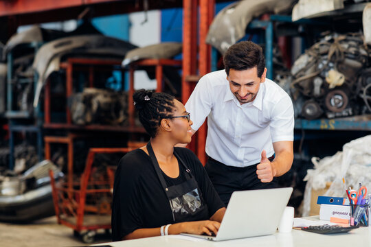 African American female worker and man customer choose and inspecting car part products while working in a old car part warehouse store. - Powered by Adobe