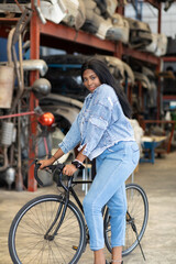 Obraz premium Big african american woman modeling. Old Machine auto parts in warehouses. Auto mechanic car service, repair and maintenance concept. used car-auto mobile spare parts