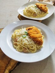 Fettucine white cream sauce with chicken katsu in white plate - Italian food style. Selective Focus
