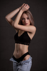 Young beautiful girl in sexy underwear, on a dark background