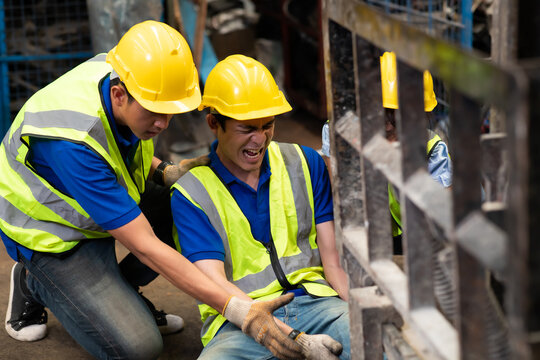 Injured Asian Man Worker After Accident In A Old Car Parts Warehouse.  Forklift Crash Leg Worker Accident