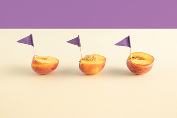 Creative summer composition with fresh peach fruits and purple flag against bright beige background. Minimal food concept.