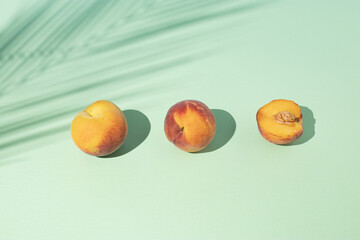 Creative summer composition with fresh peach fruits and purple flag against bright beige background. Minimal food concept.