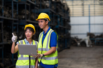 Warehouse managers and worker asian team working and discussing with desktop computer at large distribution warehouse.