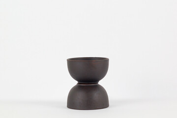 A Chinese black ceramic teapot and teacup isolated on a white background.