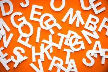 Mixed letters pile top view photo. Orange background