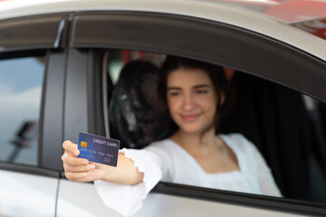 young woman driver holding and payment by credit card on gas station. Power to drive vehicles and...