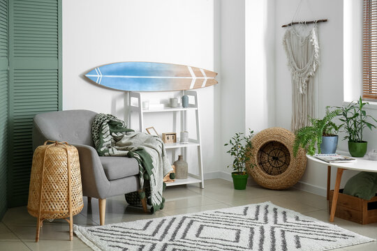 Interior of modern stylish room with surfboard and armchair
