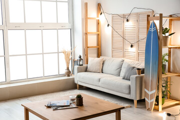 Interior of modern stylish room with surfboard and sofa