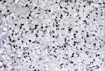 Colorful terrazzo or multicolored polished stone floor on grey background