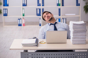 Young businessman employee unhappy with excessive work in the of