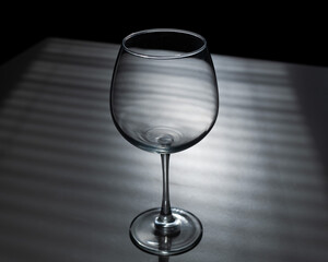 Blinds shade on a wine glass on a white table
