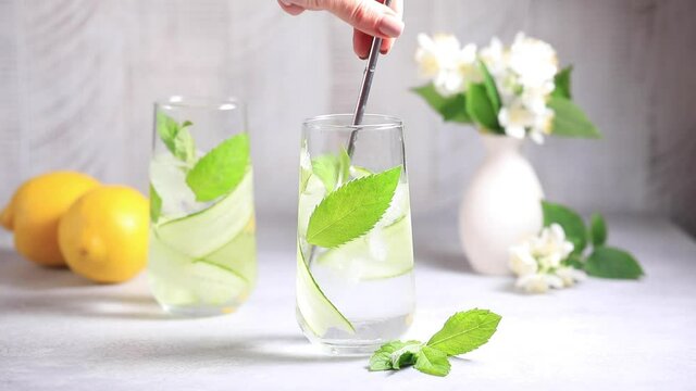 The process of making detox water with cucumber, mint and lemon juice.