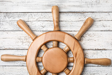 Ship helm on wooden background