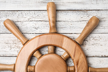 Ship helm on wooden background